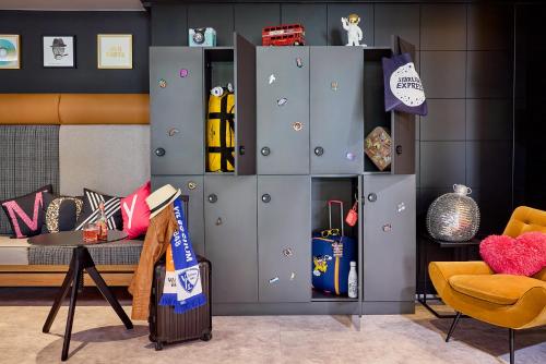 波鸿Moxy Bochum的一间设有灰色橱柜、一张沙发和一张桌子的房间