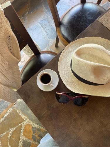 阿尔·阿尔兹Le Cedrus Hotel的一张带帽子的桌子,一杯咖啡和太阳镜