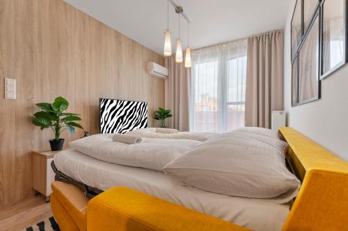 布拉迪斯拉发LAM Safari w Balcony, AC & Free parking的一间卧室配有一张大床和一张黄色的沙发