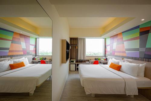 新加坡Genting Hotel Jurong的两张床位于带色彩缤纷墙壁的酒店客房