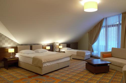 沃姆扎Hotel Via Baltica的酒店客房,设有两张床和一张沙发