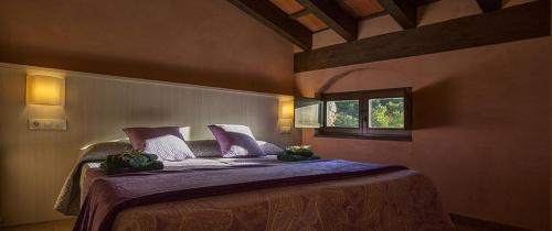 法尔塞特奇梅里斯度假屋的一间卧室配有一张带紫色床单的床和窗户。