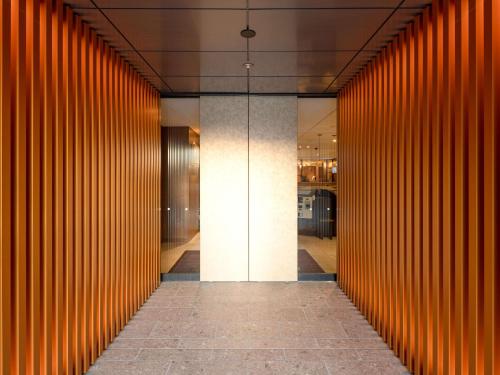 京都Comfort Hotel Kyoto Horikawagojo的一座带橙色木板的建筑的走廊