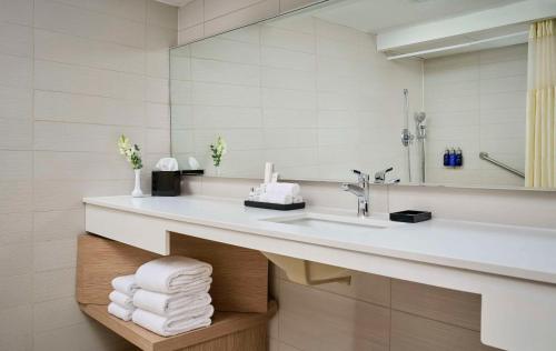 多伦多Radisson Blu Toronto Downtown的浴室配有盥洗盆、镜子和毛巾