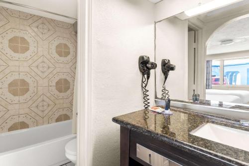 加尔维斯敦Econo Lodge Galveston Seawall的一间带水槽的浴室和台面上的电话