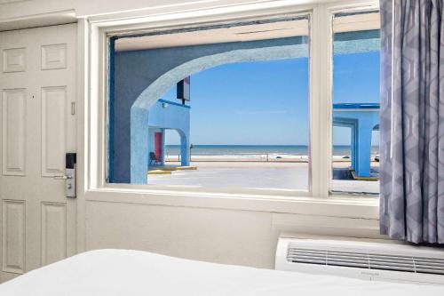 加尔维斯敦Econo Lodge Galveston Seawall的一间卧室设有窗户,享有海滩美景