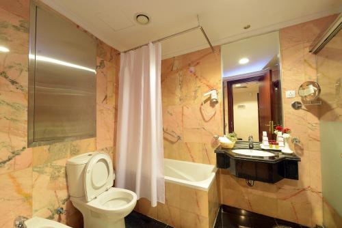 麦地那Deyar Al Eiman Hotel的浴室配有卫生间、盥洗盆和浴缸。