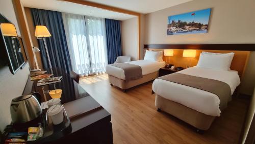 伊斯坦布尔博斯普鲁斯港酒店的酒店客房,配有两张床和椅子
