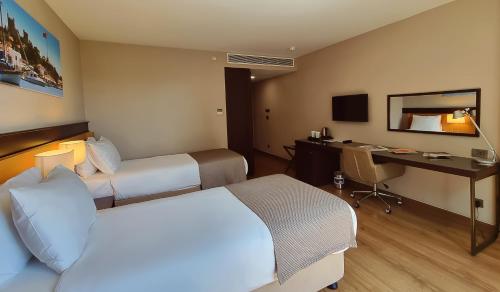 伊斯坦布尔博斯普鲁斯港酒店的酒店客房配有两张床和一张书桌