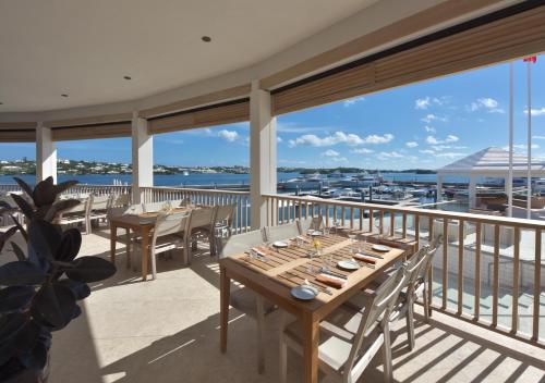 汉密尔顿汉密尔顿公主海滩俱乐部费尔蒙经营酒店的阳台的用餐室配有桌椅