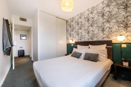 图卢兹Nemea Appart Hotel Toulouse Aéroport的一间卧室设有一张白色大床和绿色的墙壁