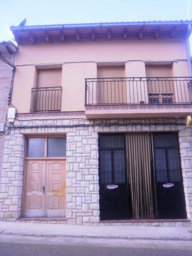 Torralba de los SisonesBar hostal Torralba de los sisones的两扇门和阳台的建筑