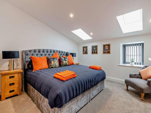 Tollerton3 Bed in Tollerton 93897的一间卧室配有一张带橙色枕头的大床