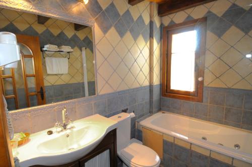 维拉诺瓦卡萨阿卡斯酒店的一间带水槽、浴缸和卫生间的浴室