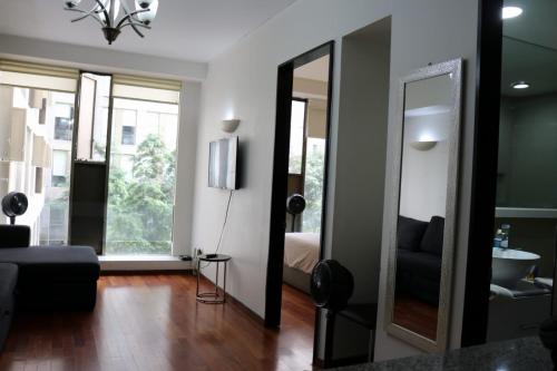 墨西哥城Puerta Alameda Suites México的一间带镜子和床的客厅