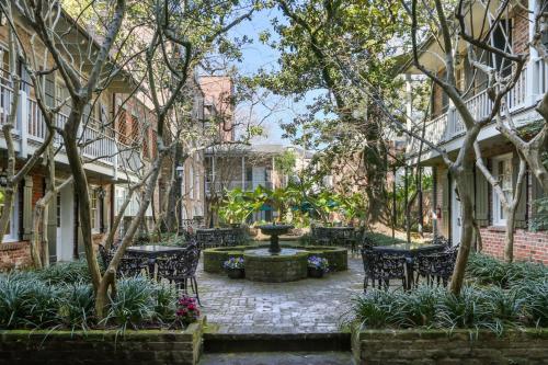 新奥尔良普雷斯迪阿梅斯酒店的庭院设有喷泉和桌椅