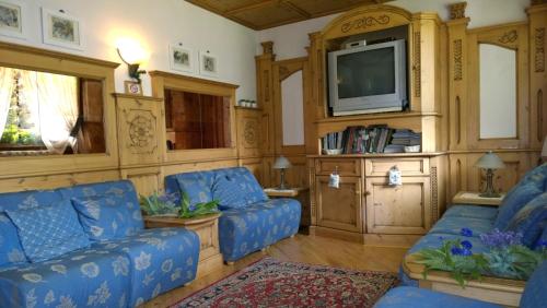 卡里索洛LA FELCE Bed & Breakfast的客厅配有蓝色的沙发和电视