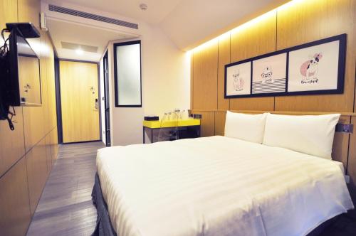 台中市逢甲25行館Fengjia 25 Hotel的一间酒店客房,配有一张白色大床