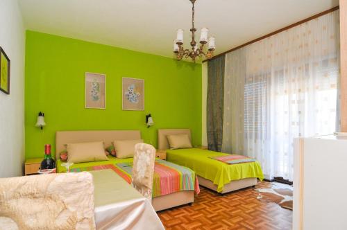 蒂瓦特兰卡旅馆的绿色卧室配有两张床和椅子
