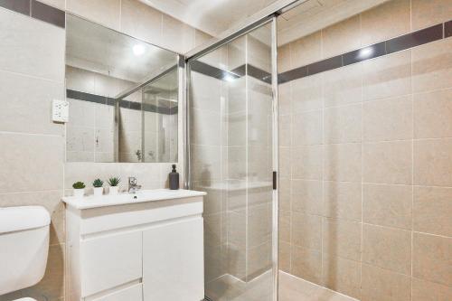 悉尼Stylish 2 Bedroom Apartment Haymarket的带淋浴和盥洗盆的浴室