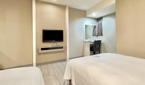 斗六市致丽伯爵酒店的配有一张床和一台平面电视的酒店客房