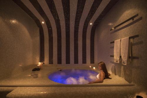 费拉Aressana Spa Hotel & Suites - Small Luxury Hotels of the World的坐在浴室浴缸里的女人