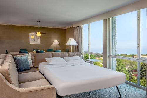 斯科基芝加哥-北海岸会议中心枫林希尔顿酒店的卧室配有一张白色的大床和一张沙发。