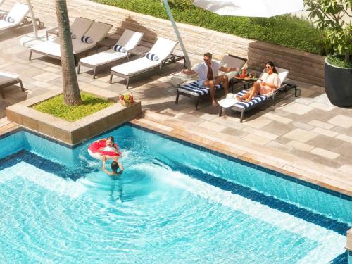 迪拜迪拜古赖尔瑞士酒店的一群人坐在游泳池里