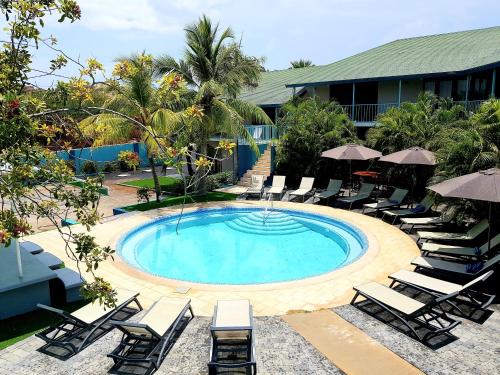 简蒂埃尔Boutique Hotel & Apartments Route 66 Curacao的度假村内带椅子和遮阳伞的游泳池