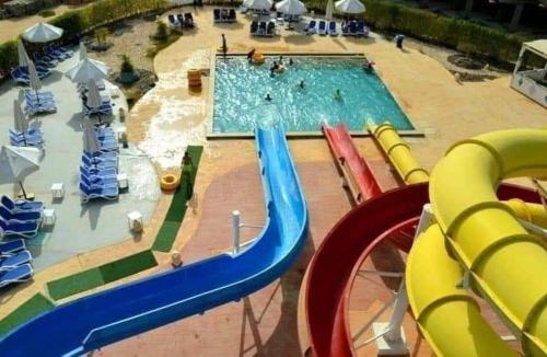 沙姆沙伊赫Apartment in Porto Sharm VIP的一个带游泳池和滑梯的水上公园