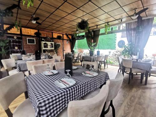 皮罗特Hotel style rooms & restaurant Pirocanac的餐厅配有黑白格子桌和椅子