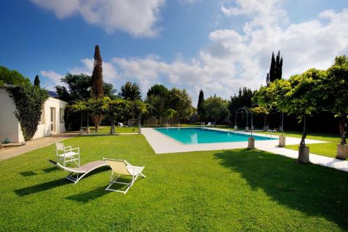 穆罗莱切塞Tenuta Sant'Andrea的一个带两把椅子的庭院和一个游泳池