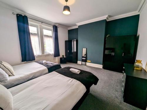 盖茨黑德2 Bedroom, Spacious, Close To Newcastle&gateshead的一间卧室设有两张床和绿色的墙壁