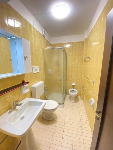 利尼亚诺萨比亚多罗Residence Luna的浴室设有2个卫生间、水槽和淋浴。