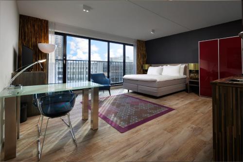 埃因霍温WestCord Hotel Eindhoven的一张床铺、一张桌子和一张床