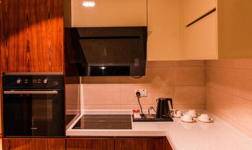马斯喀特City Park Hotel Apartments的厨房配有黑色微波炉和炉灶。