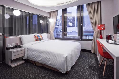 台北V-one - 宁夏2号旅店的配有一张床、一张书桌和一扇窗户的酒店客房