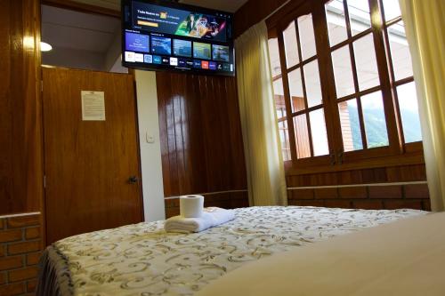 奥克萨潘帕Hospedaje Vista Verde的一间卧室配有一张床、电视和毛巾