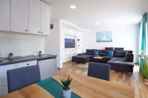 SurčinAirport Stay Apartments的厨房以及带沙发和桌子的客厅。