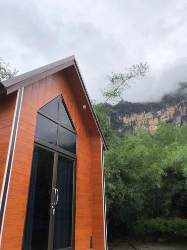 Ban PhônmuangCool Pool Bungalow的一座带窗户的建筑,背景是山