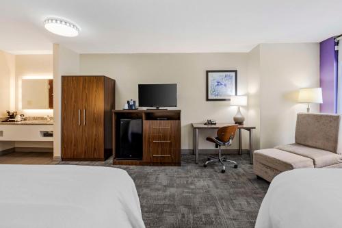 孟菲斯让X贝斯特韦斯特PLUS酒店的酒店客房带一张床、一台电视和一把椅子