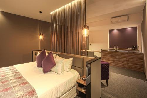 普埃布拉Kharma Suites的酒店客房,配有床和电视
