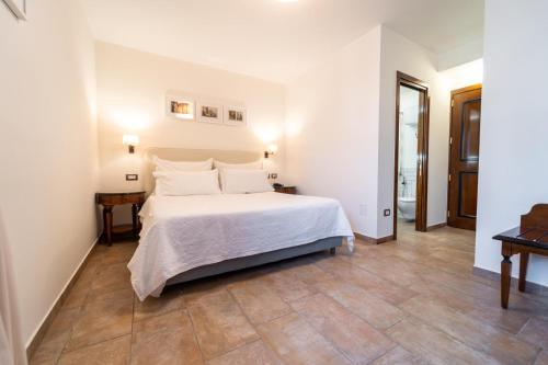 马里利亚诺戴尔安吉洛酒店的卧室配有白色的床,铺有木地板