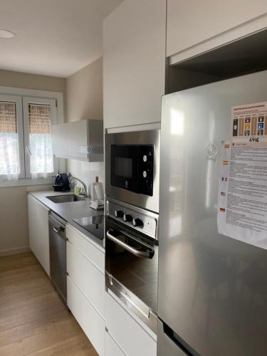 卡尔多纳La Rotonda的厨房配有不锈钢用具和白色橱柜
