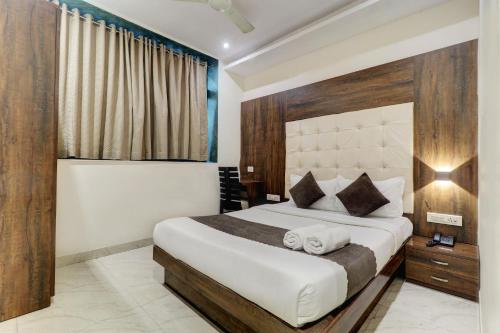 孟买Hotel A. K. International - Fort的一间卧室设有一张大床和一个窗户。