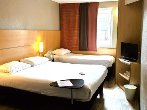 卡莱尔卡莱尔宜必思城市中心酒店的酒店客房设有两张床和电视。