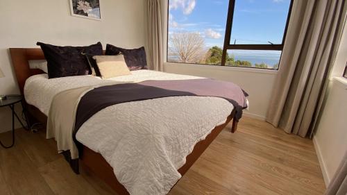 泰晤士Fantail Hill的一间卧室设有一张床和一个大窗户