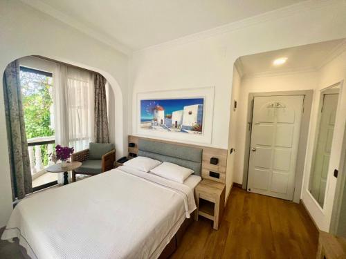 马尔马里斯卡瑞克西酒店的卧室设有一张白色大床和一扇窗户。