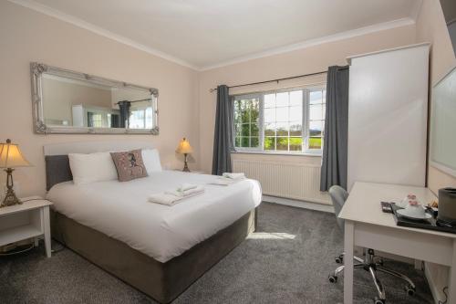 莫尔德Northop Hall Country House Hotel的一间卧室配有一张床、一张书桌和一个窗户。