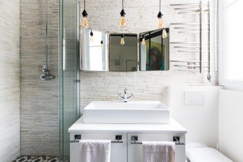 巴黎MONTMARTRE ROMANTIC - chambres d'hôtes de charme à Montmartre - Paris的浴室设有白色水槽和镜子